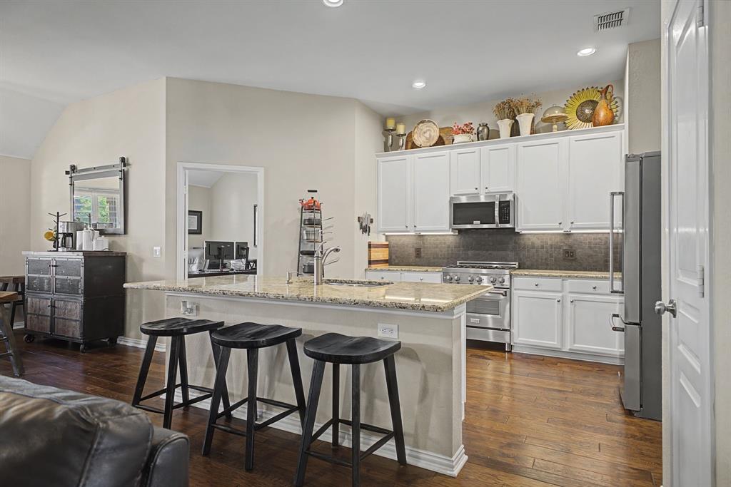 505 Scenic Ranch Circle Fairview, TX 75069 - Photo 14 of 32 a kitchen with stainless steel appliances granite countertop a table chairs sink and cabinets