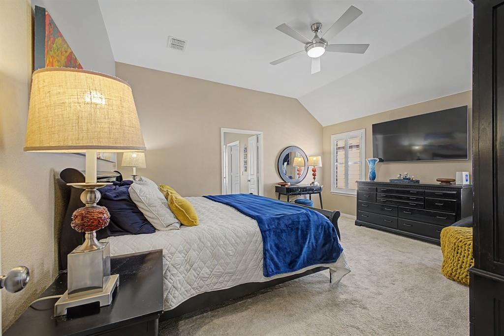 505 Scenic Ranch Circle Fairview, TX 75069 - Photo 16 of 32 a bedroom with a bed and a flat tv screen on the dresser