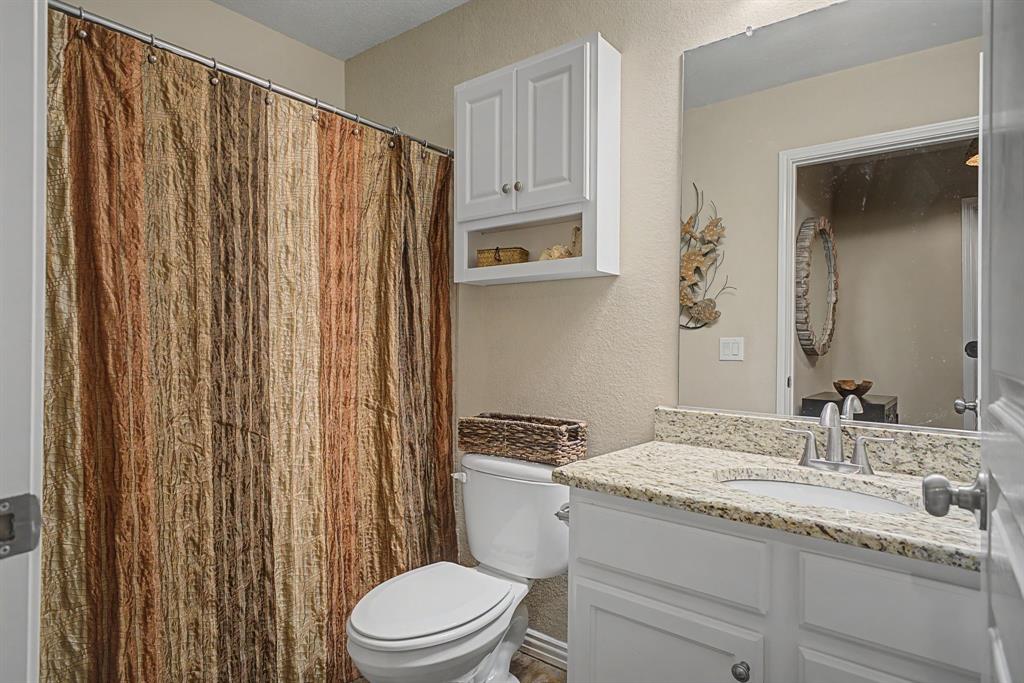 505 Scenic Ranch Circle Fairview, TX 75069 - Photo 20 of 32 a bathroom with a granite countertop sink toilet and shower