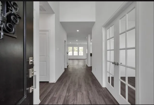 a view of an empty room with wooden floor