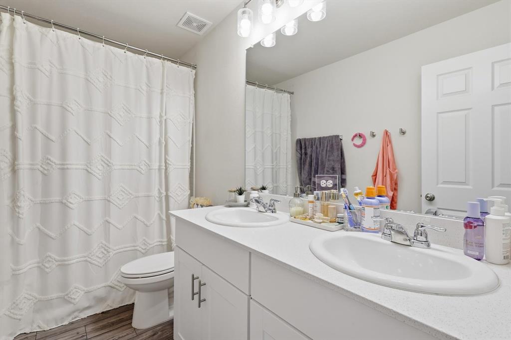 16041 Pious Drive Haslet, TX 76052 - Photo 21 of 36 Full bath with double vanity and dark wood-type flooring