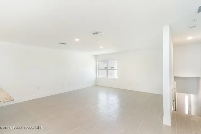 an empty room with windows and entrance