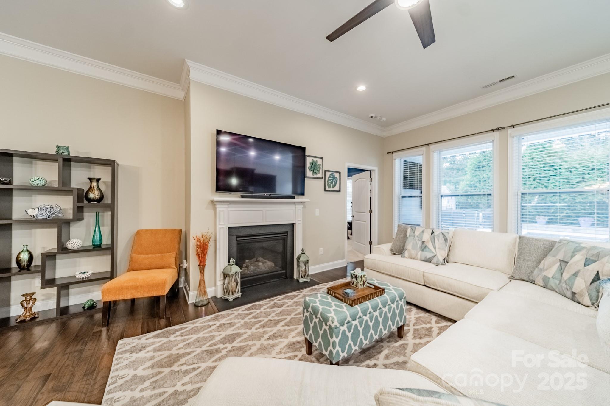 3419 Streamside Drive, Unit 463 Davidson, NC 28036 - Photo 12 of 43 a living room with furniture a flat screen tv and a fireplace