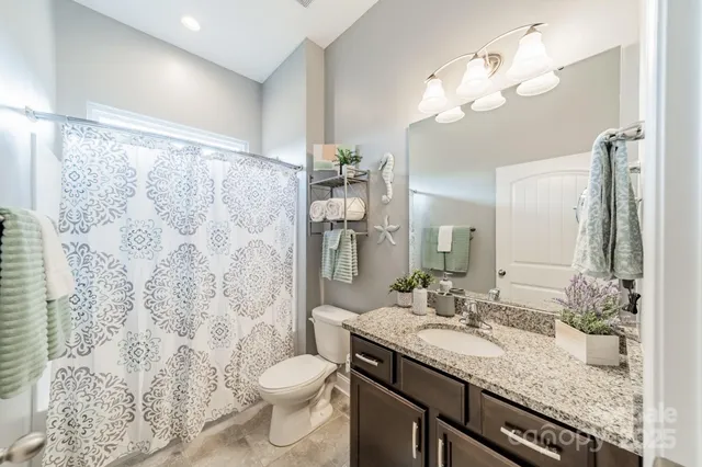 a bathroom with a granite countertop sink toilet and shower