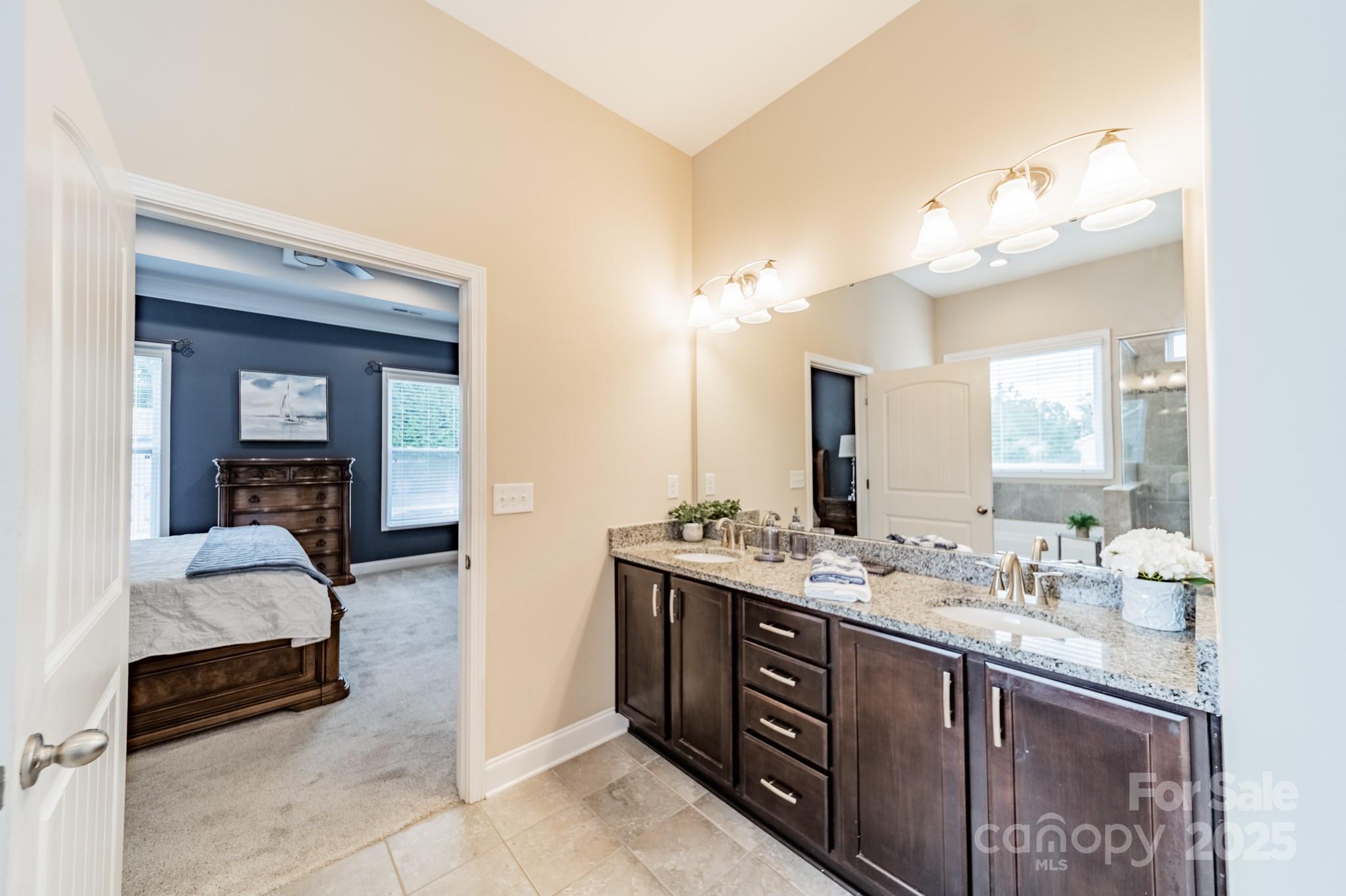 3419 Streamside Drive, Unit 463 Davidson, NC 28036 - Photo 18 of 43 a en suite bathroom with a double vanity sink and a mirror