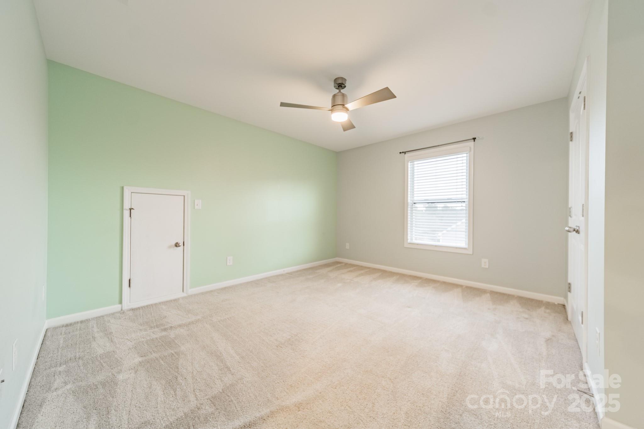 3419 Streamside Drive, Unit 463 Davidson, NC 28036 - Photo 27 of 43 an empty room with a window and a ceiling fan