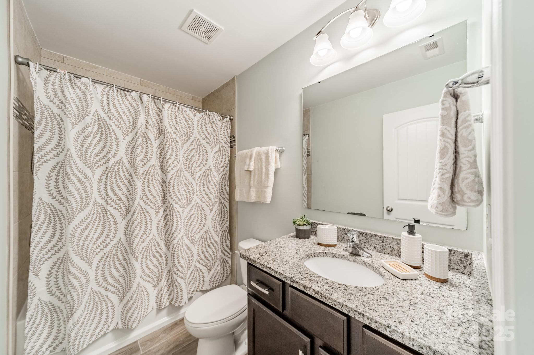 3419 Streamside Drive, Unit 463 Davidson, NC 28036 - Photo 28 of 43 a bathroom with a granite countertop sink and a mirror