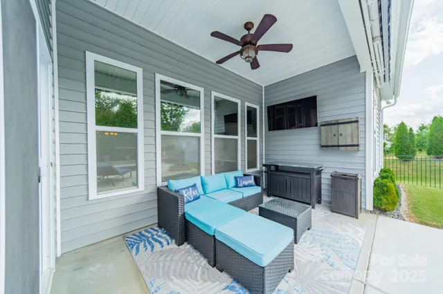 a living room with furniture a window and a ceiling fan