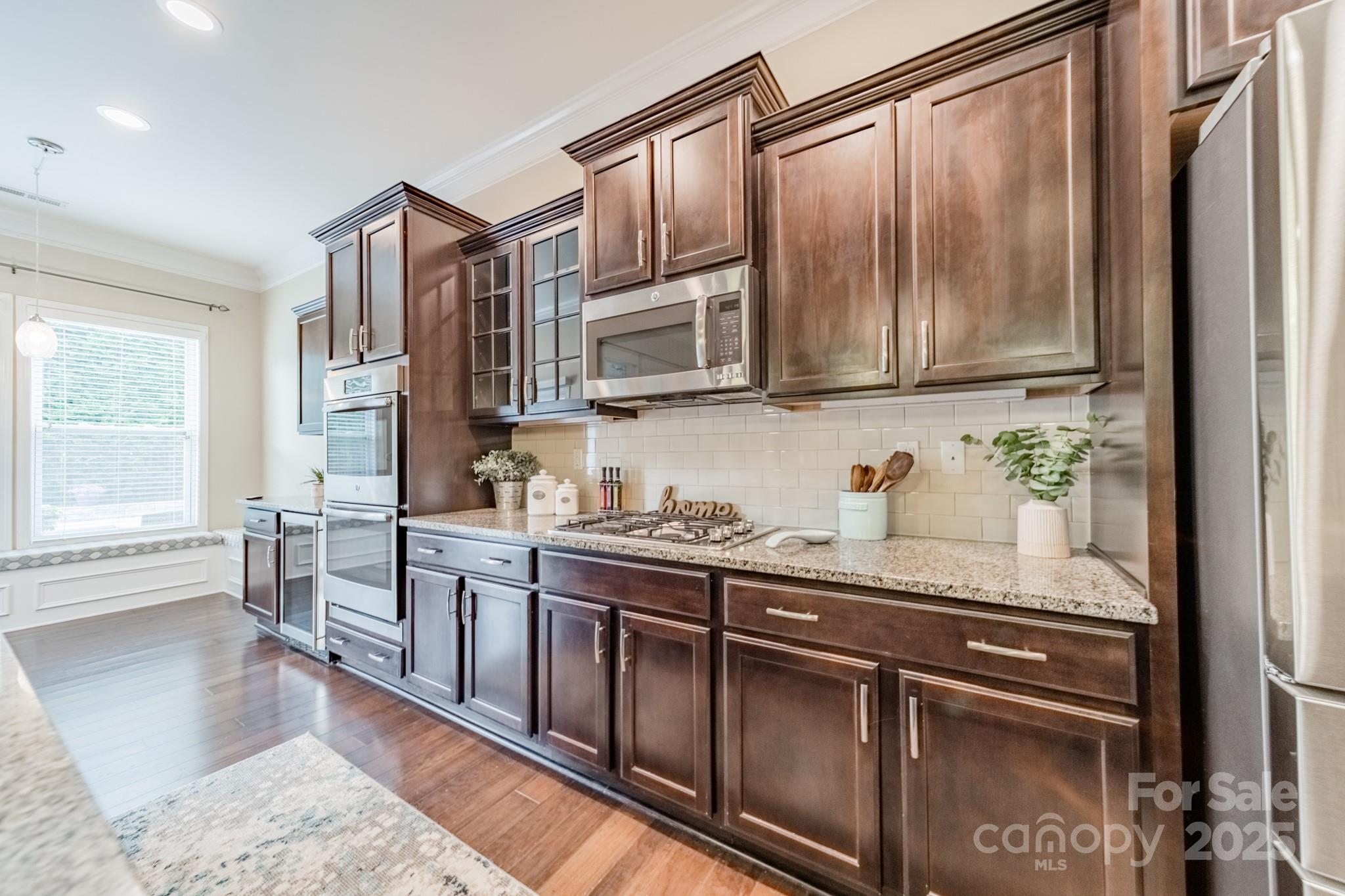 3419 Streamside Drive, Unit 463 Davidson, NC 28036 - Photo 7 of 43 a kitchen with stainless steel appliances granite countertop a stove a sink and a refrigerator