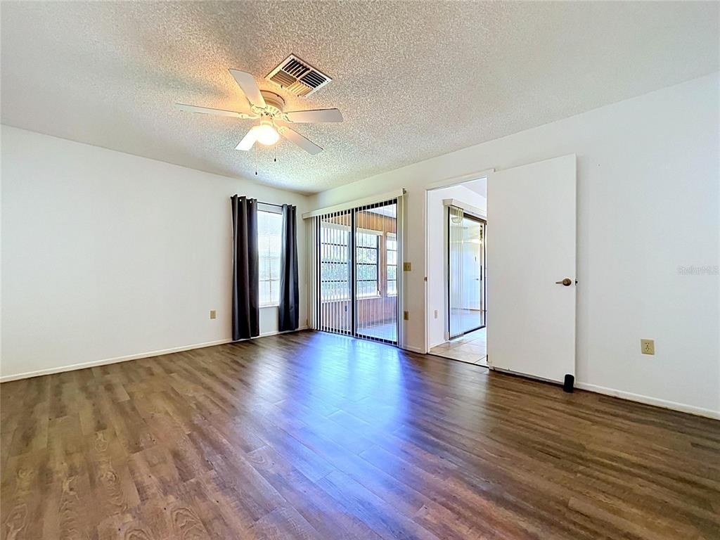 9319 Trowbridge Court New Port Richey, FL 34655 - Photo 40 of 78 a view of an empty room with wooden floor and a window
