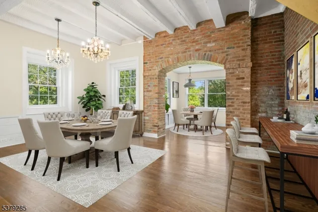 a view of a dining room with furniture a chandelier and wooden floor
