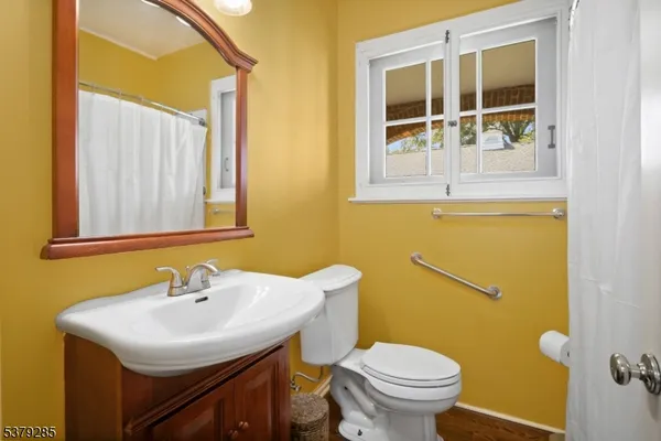 a bathroom with a sink a toilet and a mirror