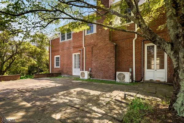 a view of a brick house with a large tree