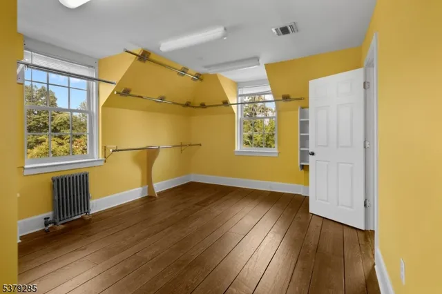 a view of empty room with wooden floor and windows