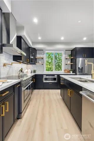 a kitchen with stainless steel appliances a white table chairs and a wooden floor