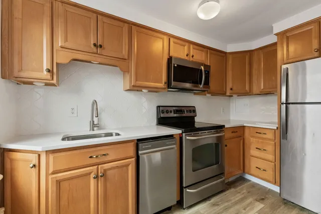 a kitchen with stainless steel appliances granite countertop a sink a stove a microwave and cabinets