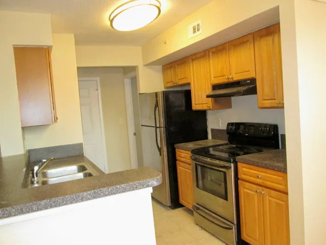 a kitchen with a stove top oven and refrigerator