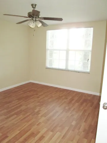 an empty room with a window and a fan
