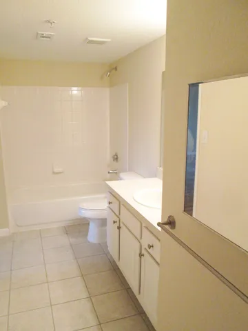 a bathroom with a granite countertop sink a toilet and bathtub