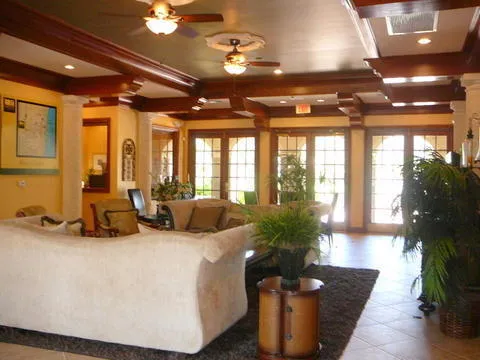 a living room with furniture fireplace and large windows