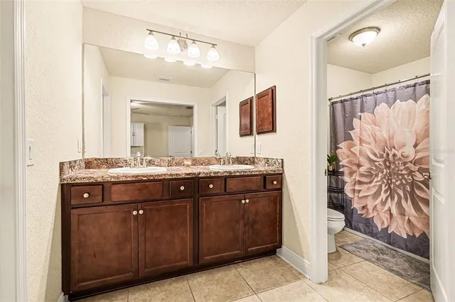a bathroom with a granite countertop sink a mirror and a shower