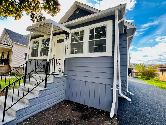 a view of a house with backyard and wooden fence