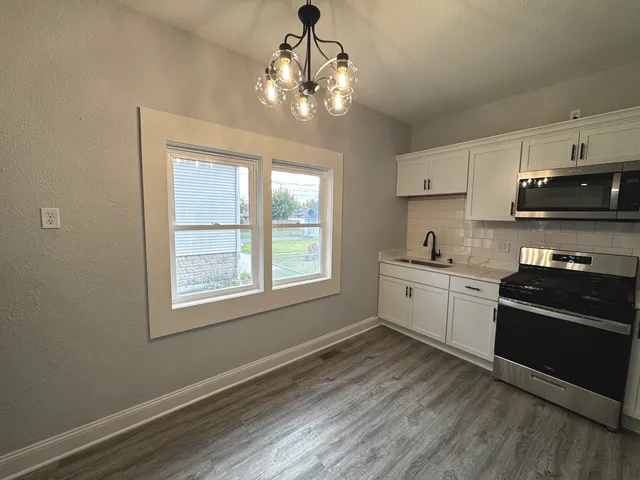 a kitchen with a sink stove and cabinets