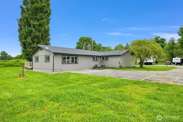 a backyard of a house with table and chairs