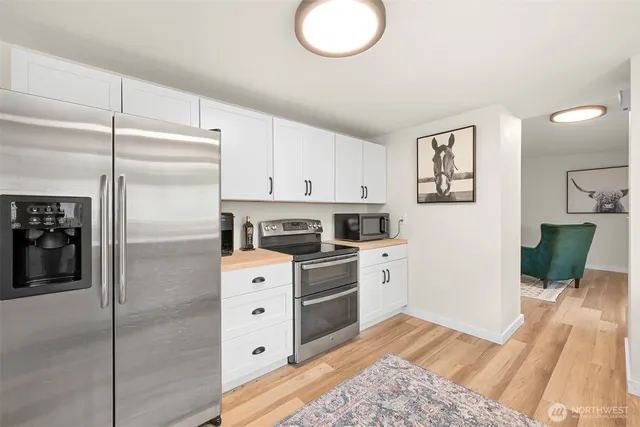a kitchen with stainless steel appliances a stove refrigerator and cabinets