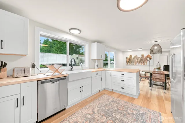 a large white kitchen with a window and a sink