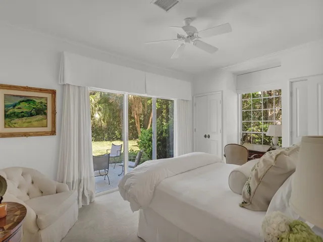 a large bedroom with a bed and glass window