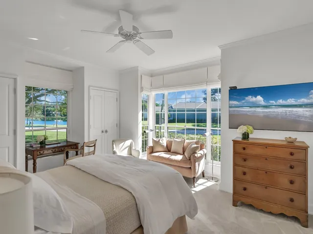 a bedroom with a bed and large windows