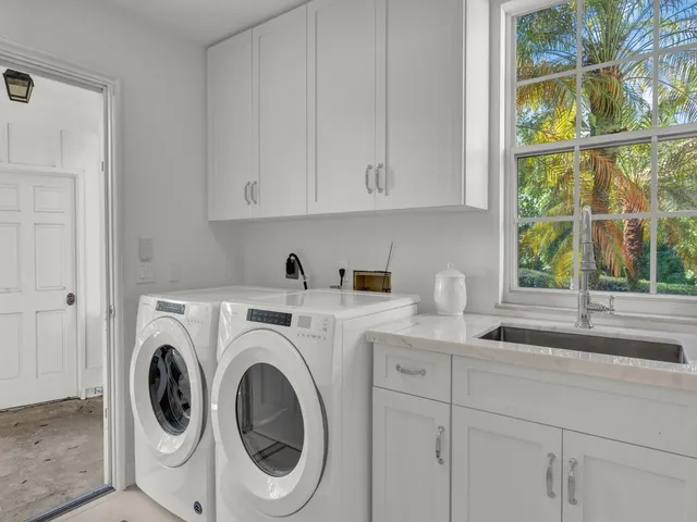 a utility room with sink dryer and washer