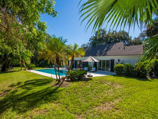 a view of a house with pool and a yard