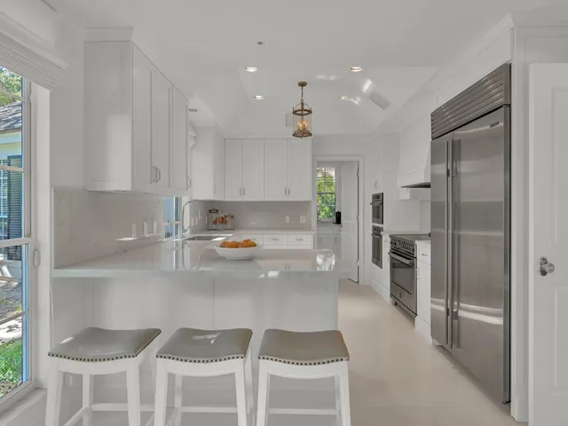 a kitchen with granite countertop a refrigerator and a stove top oven