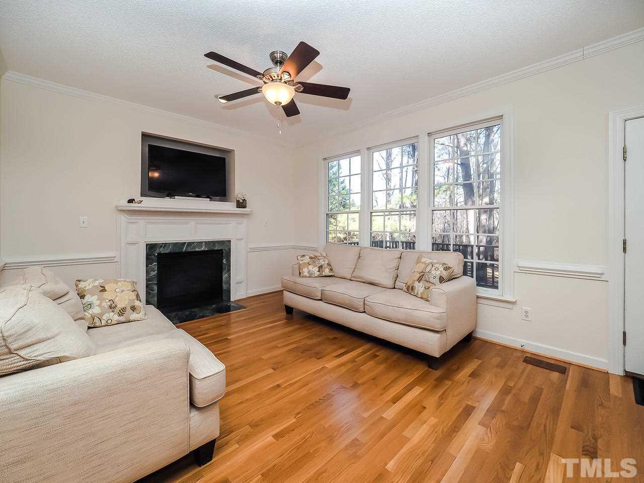 208 Priceview Drive Raleigh, NC 27603 - Photo 14 of 25 a living room with furniture a fireplace and a flat screen tv