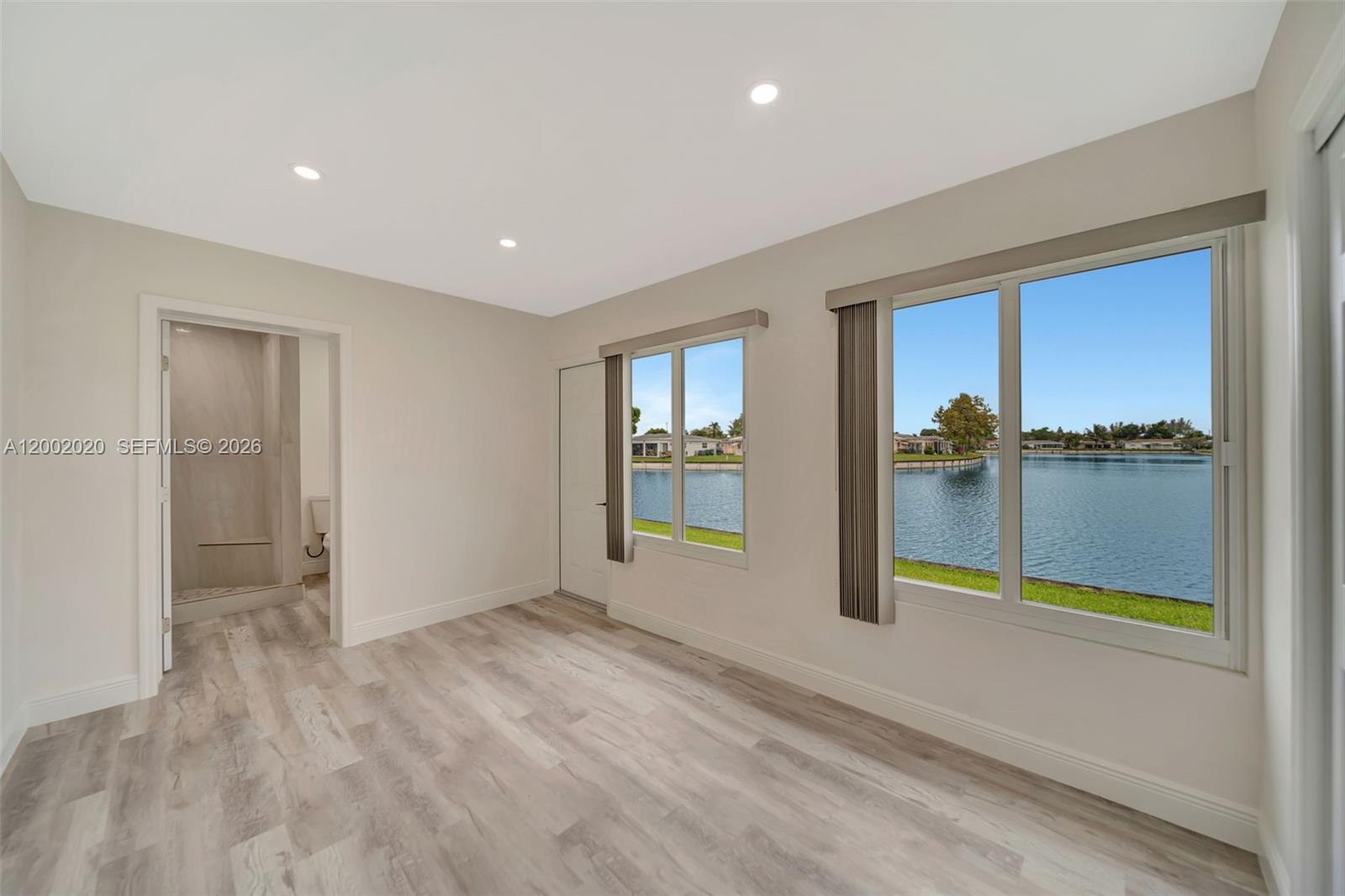 8502 Northwest 59th Street Tamarac, FL 33321 - Photo 11 of 18 an empty room with sliding door and wooden floor