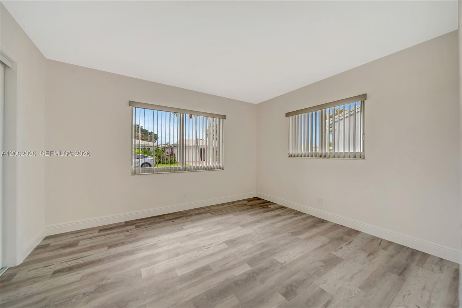 8502 Northwest 59th Street Tamarac, FL 33321 - Photo 15 of 18 a view of an empty room with window and wooden floor