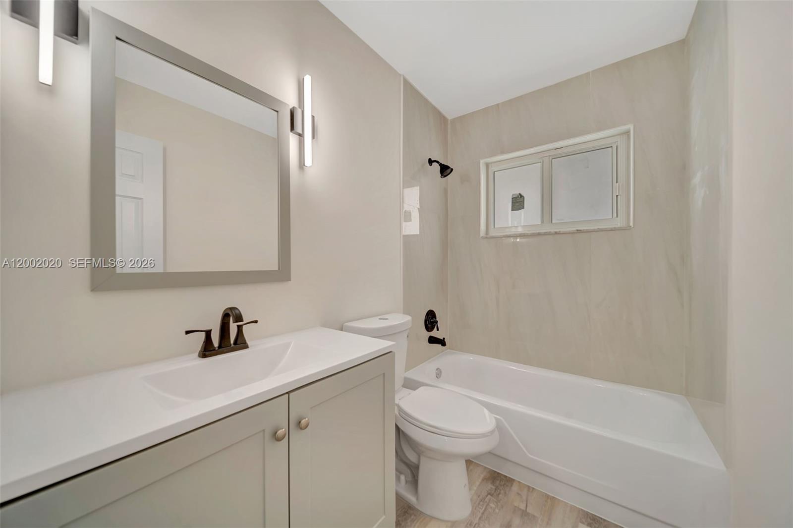8502 Northwest 59th Street Tamarac, FL 33321 - Photo 17 of 18 a bathroom with a toilet a sink a mirror and vanity