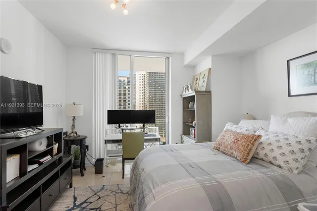 a bedroom with a bed and a flat screen tv