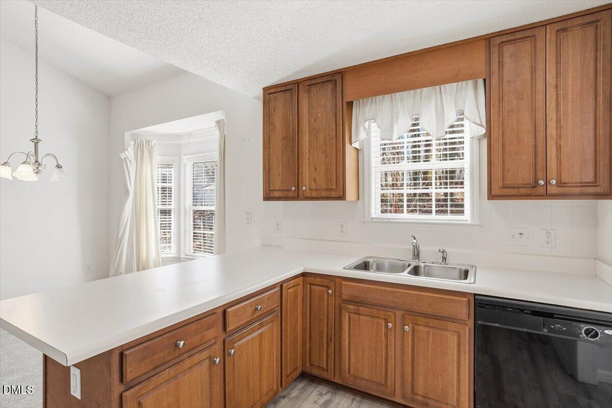 130 Muirfield Ridge Drive Garner, NC 27529 - Photo 7 of 29 a kitchen with stainless steel appliances granite countertop wooden cabinets a sink and a window