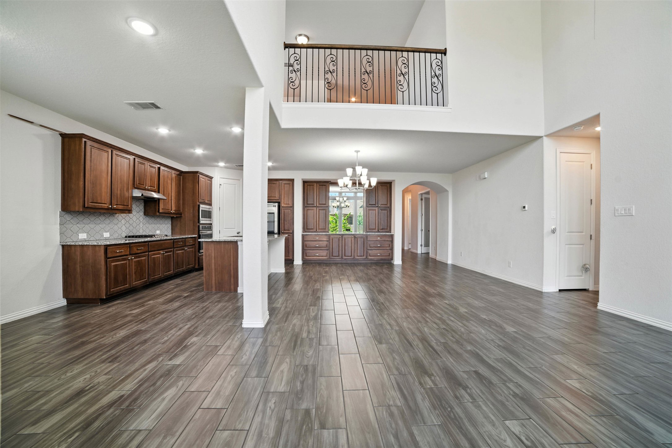 3054 Columbus Loop Round Rock, TX 78665 - Photo 39 of 40 Kitchen with arched walkways, wood finish floors, open floor plan, a chandelier, and recessed lighting