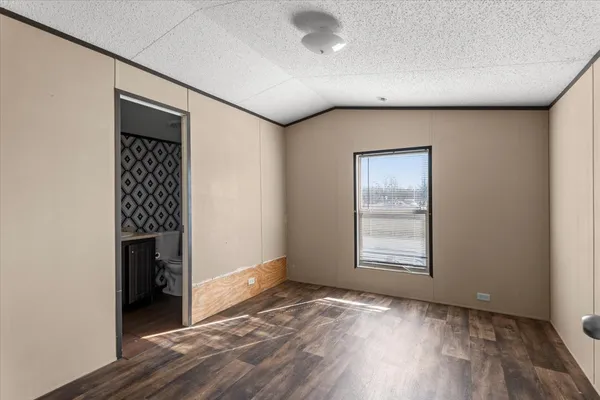 a view of a big room with wooden floor a ceiling fan and windows