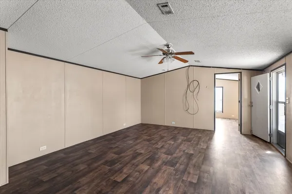 a view of a hallway with wooden floor and cabinets
