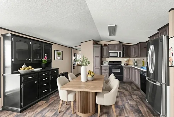 a kitchen with granite countertop a refrigerator and a stove top oven