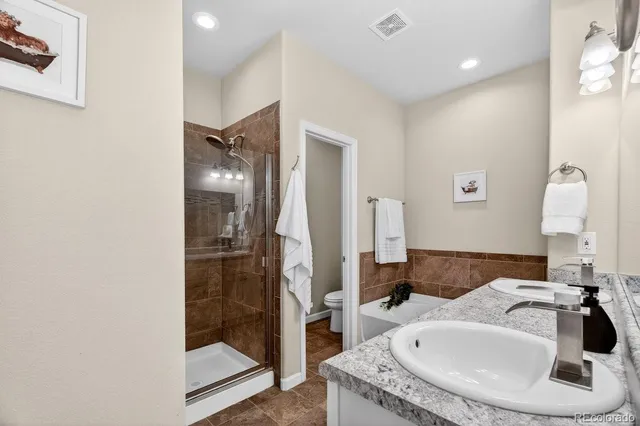 a en suite bathroom with a granite countertop sink and a mirror
