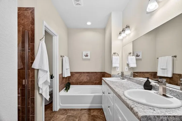 a bathroom with a granite countertop sink tub and a mirror