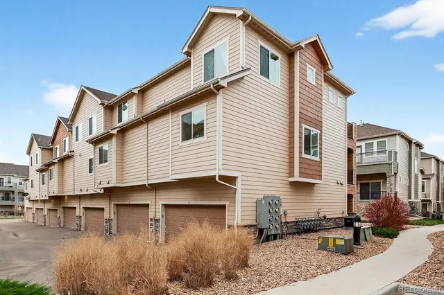 an aerial view of residential houses with outdoor space and ocean view