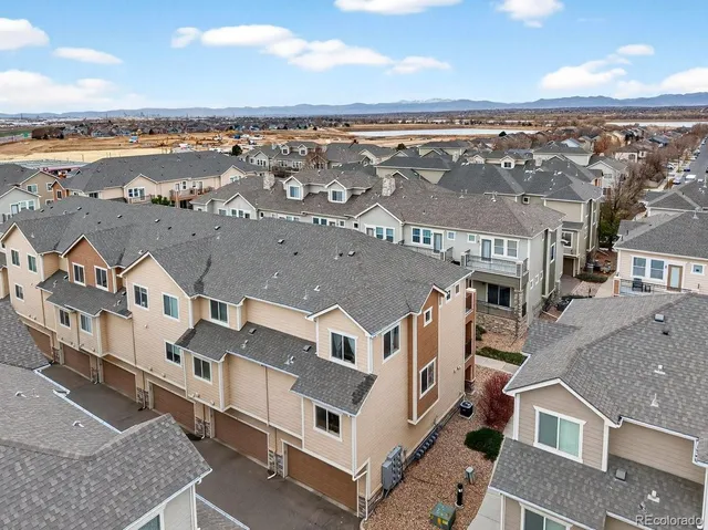 an aerial view of residential houses with outdoor space and ocean view