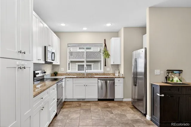 a kitchen with stainless steel appliances granite countertop a refrigerator and a stove top oven